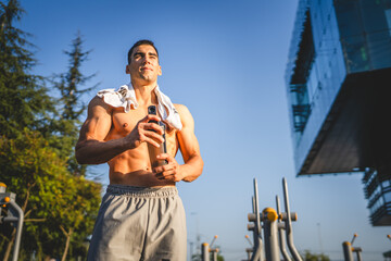 One caucasian man young male athlete take a brake during outdoor training in the park outdoor gym...