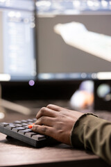 Fototapeta premium Closeup of african american person typing, inputting data into computer, improving geometry of digital machinery tool. Selective focus of black individual using keyboard and working on a cad software.