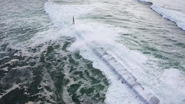 Huge waves crashing over Breakwater during winter storm Atlantic waves washing the lighthouse on Praia da Aguda sandy beach at Aguda settlement near Porto, Portugal. Incredible 4K flying drone video.