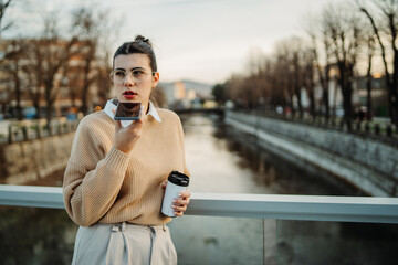 Young caucasian businesswoman use cellphone to talk or send voice messages
