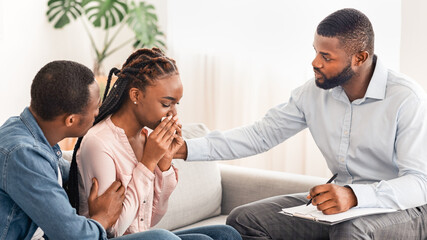 Caring Black Husband And Marriage Counselor Comforting Crying Woman During Therapy Session, Upset...