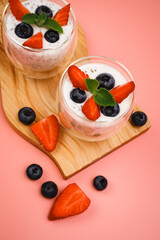 Healthy Chia Pudding in a Glass with Fresh Berries on Pink Background. Chia Pudding with...