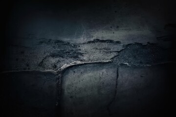 Obraz premium Abstract close-up of a textured dark surface with cracks and worn features.
