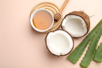 Hair treatment. Fresh coconut, honey and aloe leaves on beige background, flat lay. Space for text