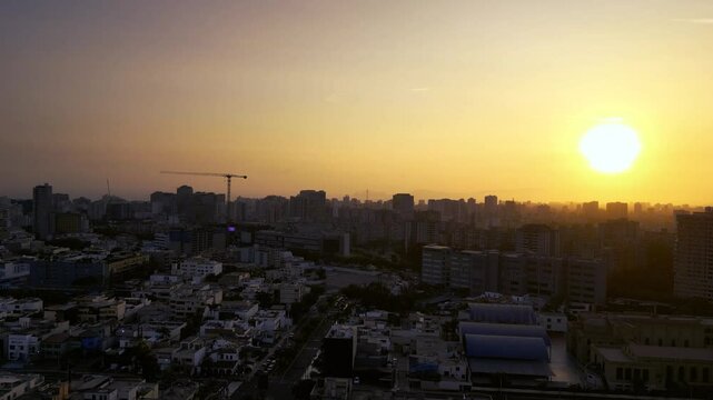 Majestic sunset over Lima with a lone bird flying across the cityscape.