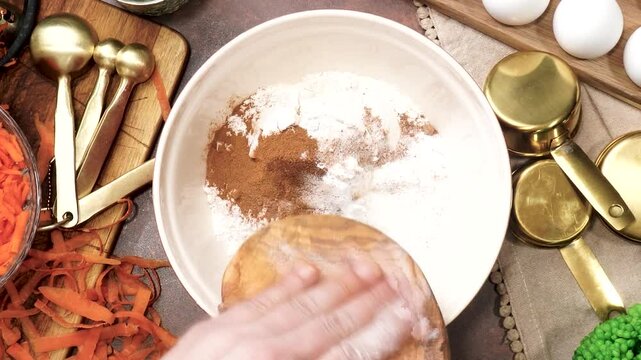 Baking a triple layer carrot cake with cream cheese icing.  A perfect spring time cake made with fresh carrots. Cake decorating with cream cheese frosting.  Homemade cake for a family gathering.