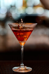 Cocktail in a martini glass with splashes on a bar counter