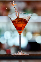 Cocktail in a martini glass with splashes on a bar counter