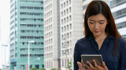 Fototapeta premium Business woman using smartphone shopping online, call, texting message internet technology lifestyle. Asian woman using cellphone walking on city street. Smart phone smart confident woman modern city