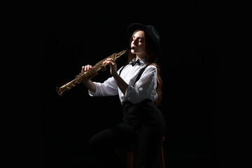 Musician playing soprano saxophone on dark background