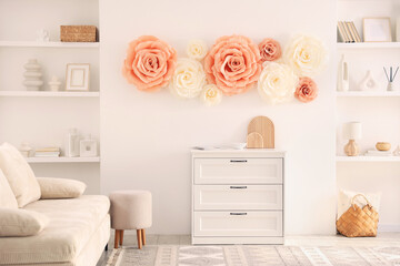 Beautiful decorative paper flowers on wall in room