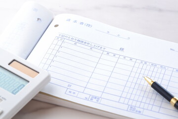 取引先に宛てた請求書を作成しているビジネスシーンのイメージ
