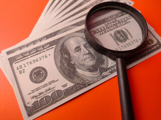Closeup magnifying glass on a one hundred dollars