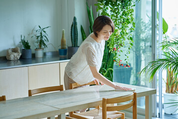 部屋を拭き掃除する女性 © maru54