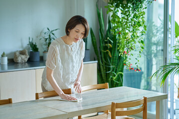 部屋を拭き掃除する女性 © maru54