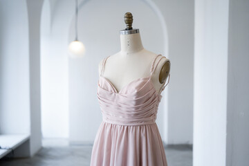 Elegant Pink Dress Displayed On Mannequin In Minimalist White Studio Space