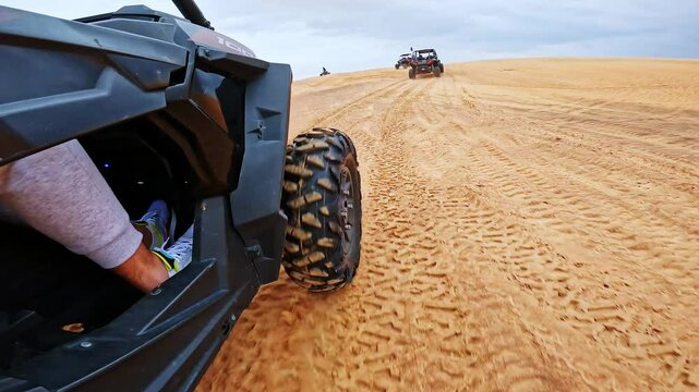 Powerful side angle shows buggy racing through soft sand on Dubai desert trails