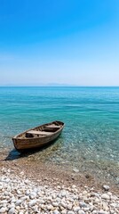 Naklejka premium Wooden boat on pebble beach clear water seascape tranquil scene