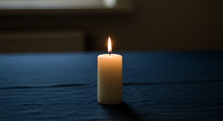 Candle Burning Brightly on a Dark Blue Surface in a Dim Room