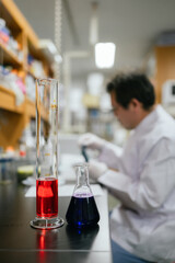 Scientific Precision: A lab technician meticulously works with vibrant chemical liquids in a state-of-the-art laboratory, a scene of meticulous scientific exploration. 