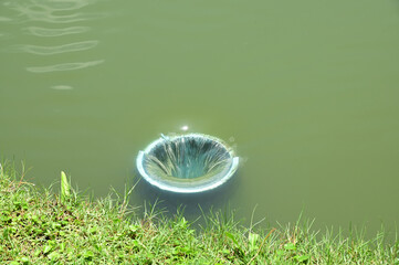 Closeup of Small drainage holes inside the pond with natural background. The concept is to prevent water from rising too high at Thailand.