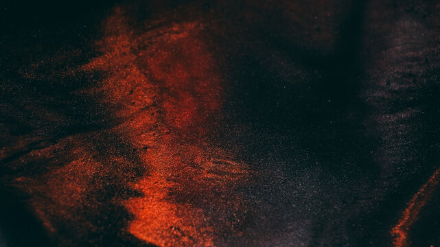 Shiny glitter. Sparkling fluid. Defocused orange bronze color ink in water chemical particles drop floating on art dark black abstraction.
