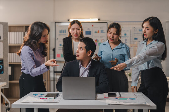 Office workers expressing frustration and blaming their manager for poor results, pointing fingers during a tense presentation in a crowded meeting room filled with stress and conflict