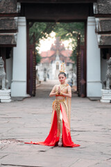 Naklejka premium Cultural portrait of a teen girl in traditional thai dress at a historic temple