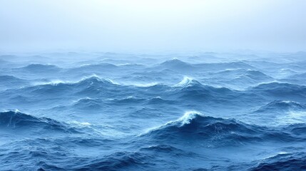 Blue waves ripple across the ocean surface, disappearing into a foggy horizon