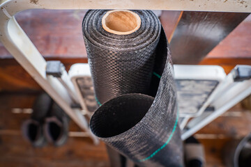 Roll of black reinforced agrofibre close-up. Reinforced film for covering the soil from weeds