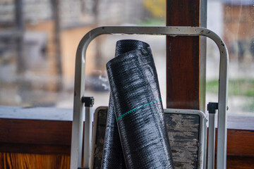 Roll of black reinforced agrofibre close-up. Reinforced film for covering the soil from weeds