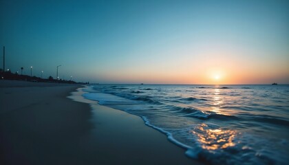 Obraz premium Seaside Serenity at Sunset: A mesmerizing view of a calm sea at dusk, the sun descending gracefully towards the horizon. The scene showcases a tranquil beach with the soft sounds of waves. 