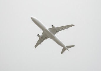 Obraz premium A white airplane is flying in the sky with its wings and engines visible against a pale background