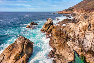 Fototapeta premium Stunning coastal landscape along California's Highway 1, featuring rugged rocky formations, and the vast blue ocean. A breathtaking natural scene showcasing the raw beauty of the Pacific coastline