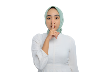 Beautiful young Asian woman in green hijab and white blouse making shushing gesture with finger on lips isolated on transparent background