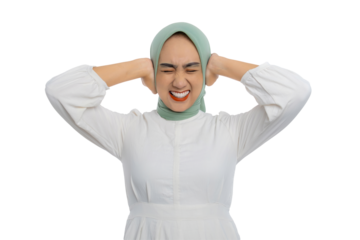 Annoyed young Asian woman in green hijab and white blouse covering her ears with hands and eyes closed isolated on transparent background