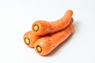 Close up view of four (4) fresh carrots isolated on white background. Clipping path. Pile, stack.