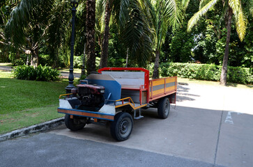BANGKOK, THAILAND - April 19, 2025 : Closeup of The Old Car E-Taen (Thai farmer's car) with flowers parked in the garage at Thailand.