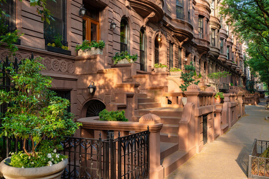 Sun-dappled Manhattan brownstones and townhouses with entry steps in late afternoon. Summer in Upper West Side Central Park West Historic District, New York City