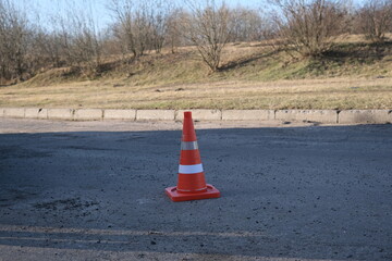A traffic cone for road works stands on the road outdoors