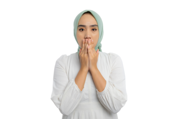Surprised young Asian woman in green hijab and white blouse covering her mouth with both hands, showing amazed expression isolated on transparent background