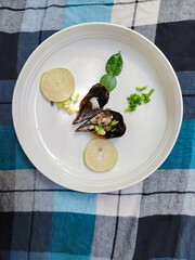 a plate of sea scallops with sliced ​​lemon and vegetables