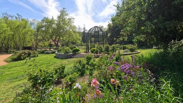 footage of a gorgeous spring landscape with a gazebo, colorful flowers and lush green trees and plants at Descanso Gardens La Canada Flintridge California USA