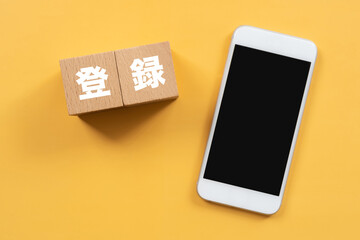 登録と書かれたブロックとスマホ