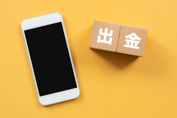 出金と書かれたブロックとスマホ