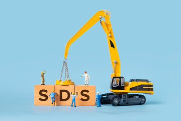 The word SDS is written on a wooden box, miniature people and excavator trucks make up the box.