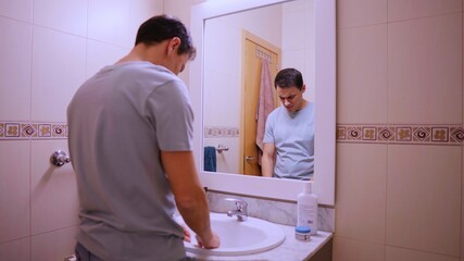 Fototapeta premium Depressed man leaning on the sink reflecting on his problems