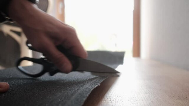 Creating a cutting edge on a griptape with scissors. Typical process when setting up a new board.