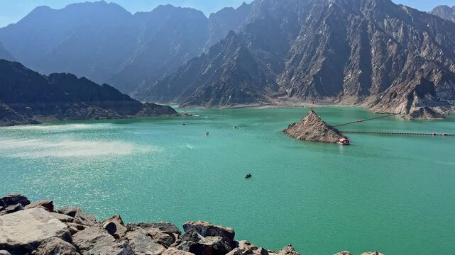 Beautiful landscape view of Hatta Dam lake and Hajar Mountains in Dubai, United Arab Emirates, showcasing serene waters surrounded by rugged mountain peaks and clear skies