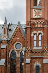 Architectural styles of the Catholic Church, view from below. Fragment of the decoration of the church in the neo-Gothic style. Roman Catholic church made of brick in the neo-Gothic style